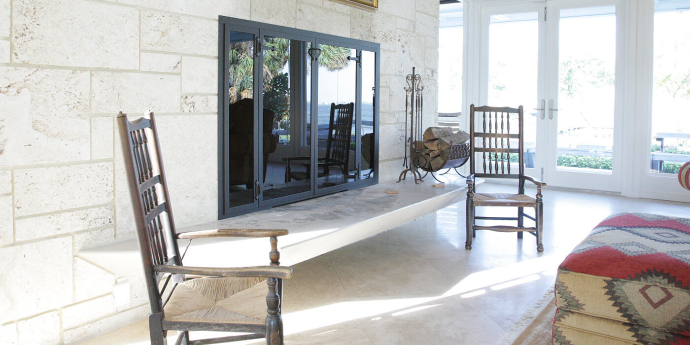 A living room with a large gas fireplace fitted with glass doors 